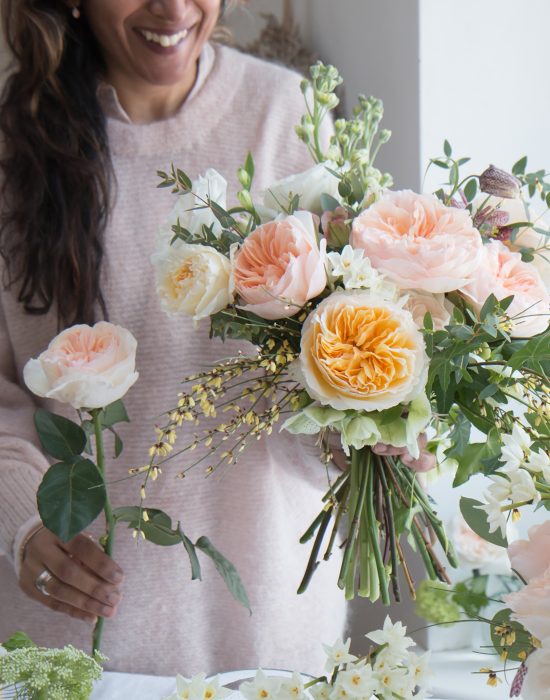 Fleuriste créant un bouquet de printemps à l'aide de roses coupées David Austin